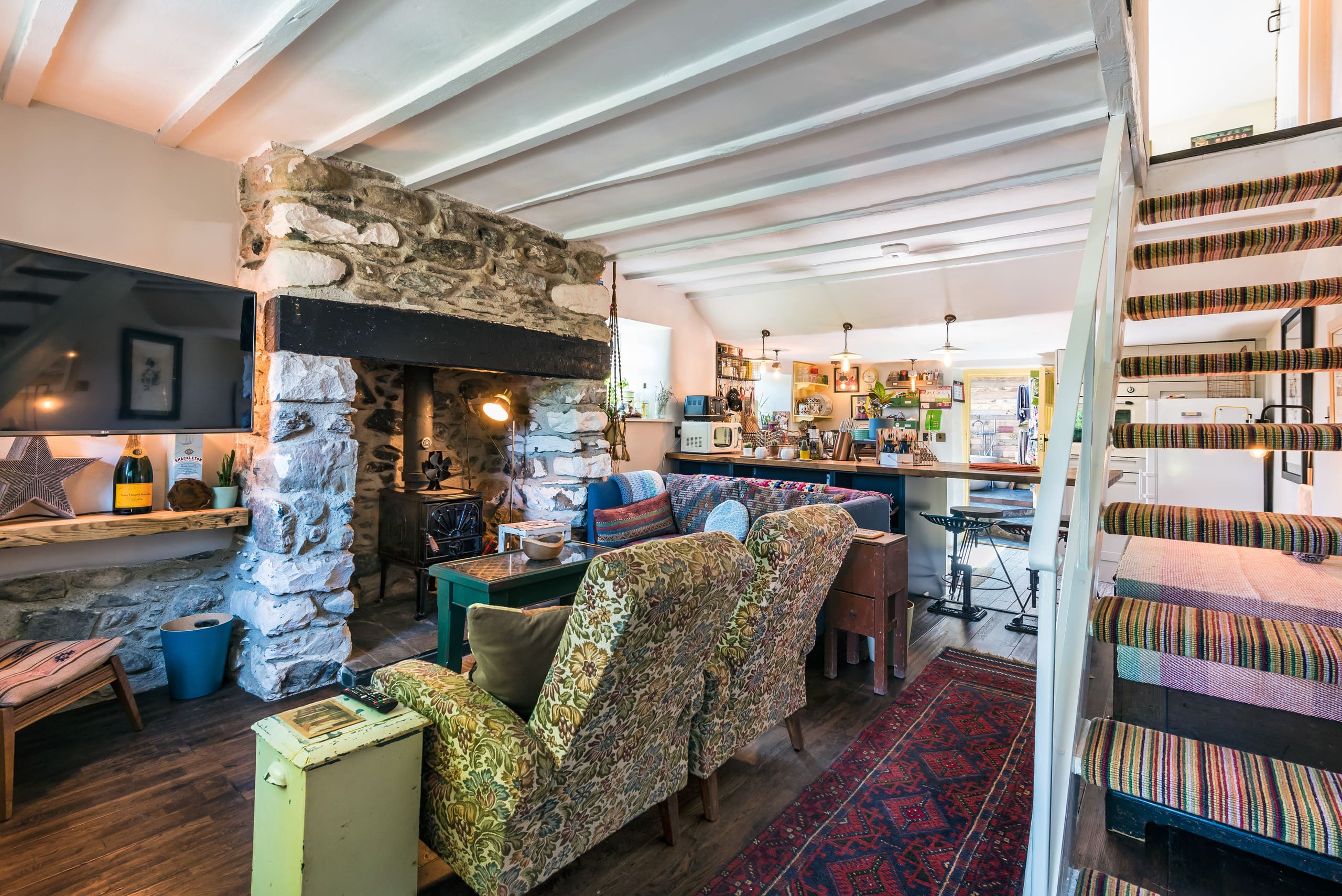 Living room: seating, stove, television at Apple Tree Cottage, North Wales